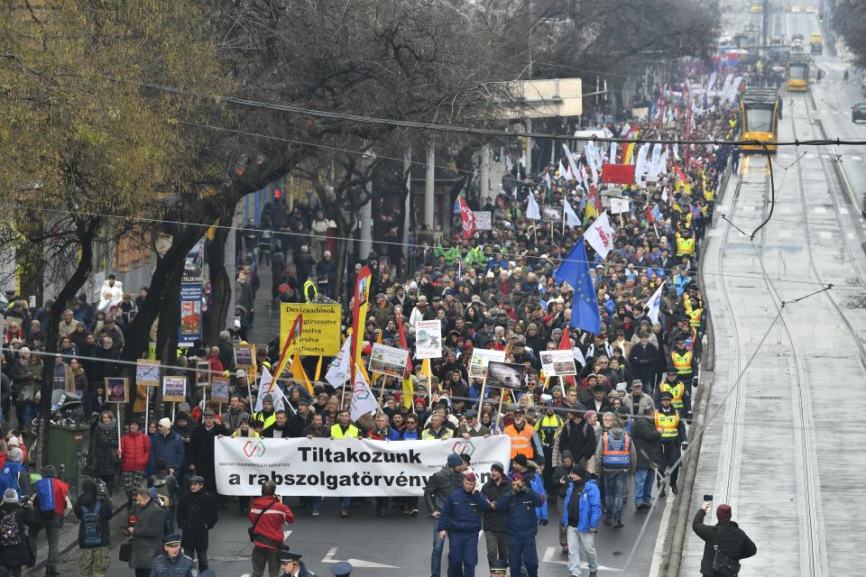 Participants march on the Szent Istvan Boulevard during the demonstration of the Hungarian Trade Union Confederation in Budapest, Hungary, Saturday, Dec. 8, 2018. The protest was held against planned 50 days overwork in a year and for freedom of scientific research and the freedom of education. (Zsolt Szigetvary/MTI via AP)