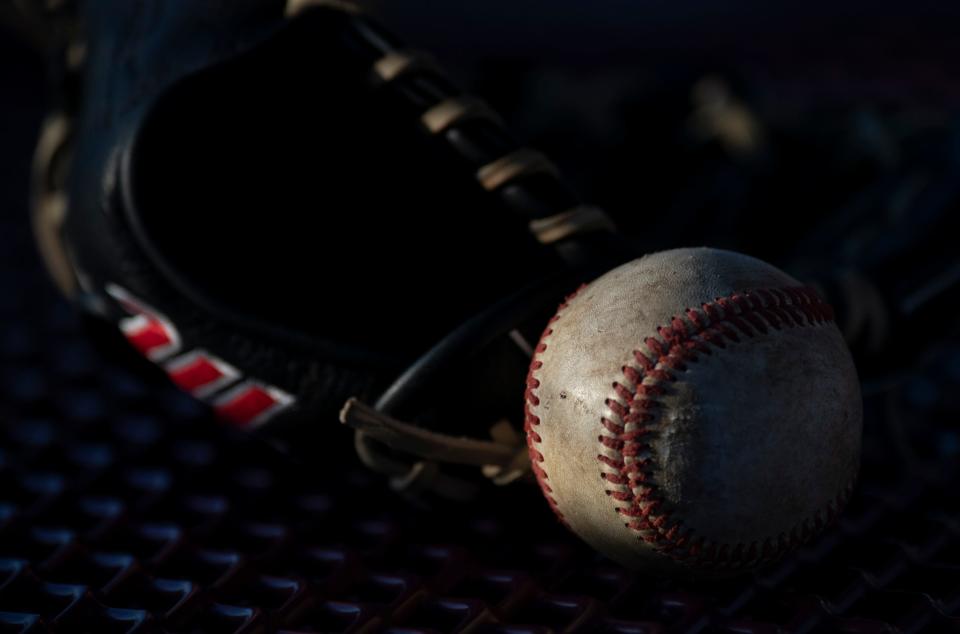 A baseball and mitt lie on table outside the baseball field at Mount Vernon High School in Mount Vernon, Ind., Friday night, April 1, 2022. Baseballs have increased about 30% in price over the past couple of years. 