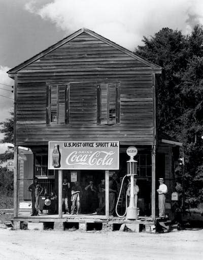 Coca-Cola’s marketing strategy emphasizes that a cold Coke should always be within reach. It started with outlets throughout the rural U.S. South, like this gas station and post office in Sprott, Alabama, photographed in 1935. <a href="https://www.gettyimages.com/detail/news-photo/locals-gather-on-the-porch-of-the-southern-cross-road-news-photo/514884972" rel="nofollow noopener" target="_blank" data-ylk="slk:Bettman via Getty Images;elm:context_link;itc:0;sec:content-canvas" class="link ">Bettman via Getty Images</a>