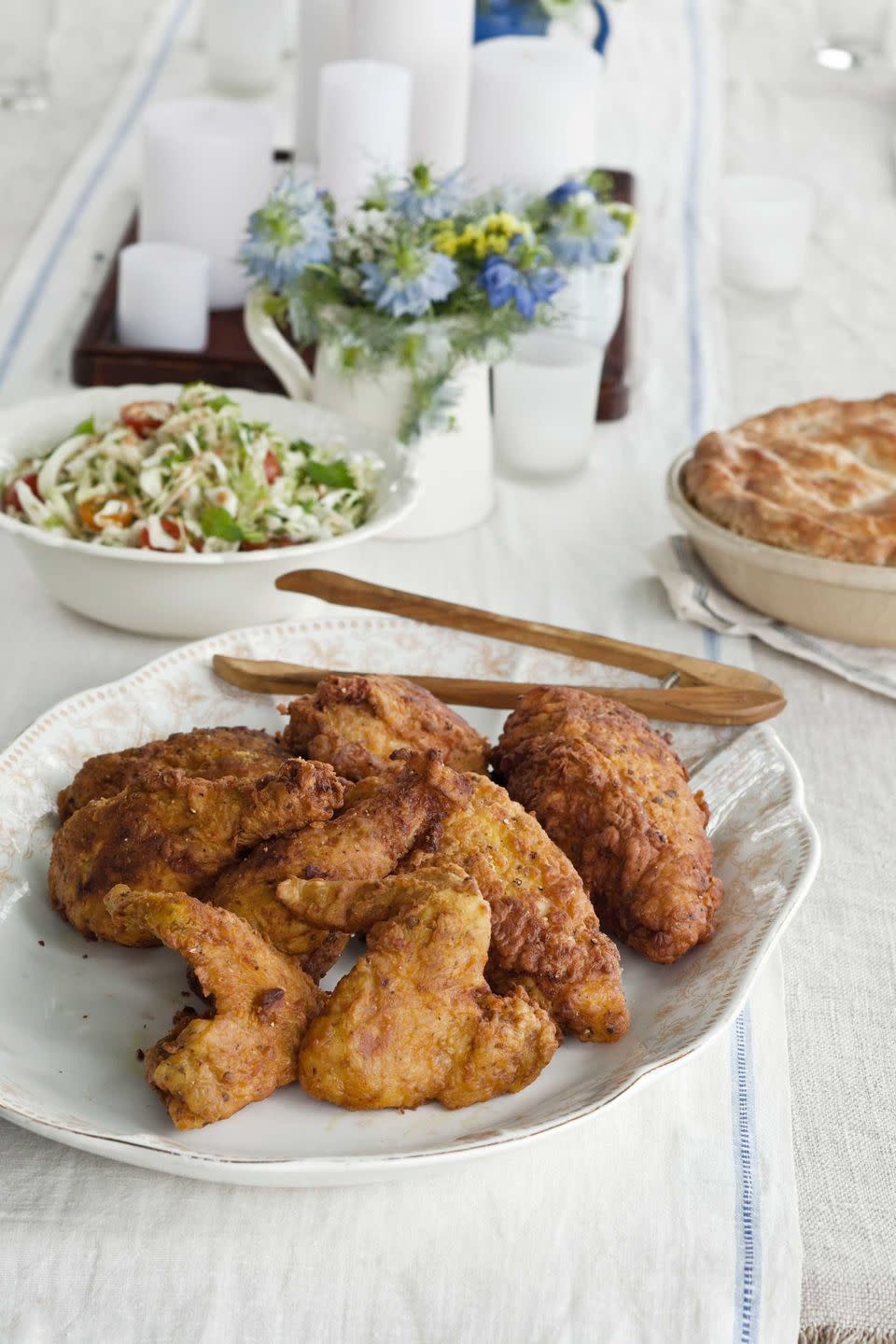 buttermilk brined fried chicken masala on an oval serving plate with tongs