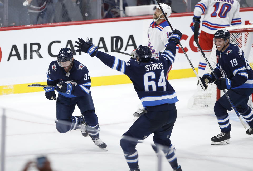 Winnipeg Jets' Sam Gagner (89), Logan Stanley (64) and David Gustafsson (19) celebrate Gagner's goal against the New York Rangers during the third period of an NHL hockey game Friday, Oct. 14, 2022, in Winnipeg, Manitoba. (John Woods/The Canadian Press via AP)