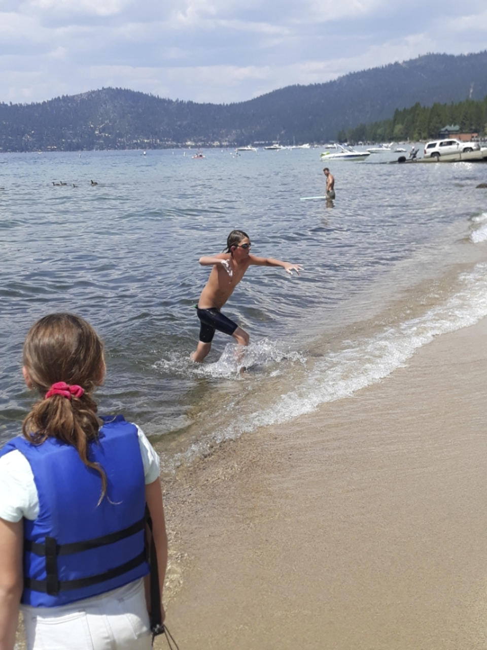 This Aug. 1, 2021 image provided by Jillian Savage shows James Savage, 14, of Los Banos, Calif. at Lake Tahoe on Aug. 1, 2021 as leaves the water after completing a swim of the entire 21.3-mile length of the alpine lake from South Lake Tahoe, California to Incline Village, Nevada. He became the youngest person ever to make the swim and complete the coveted Tahoe Triple Crown. He completed the two other legs of the triple crown earlier, each 10 miles are longer. (AP Photo/By Jillian Savage).