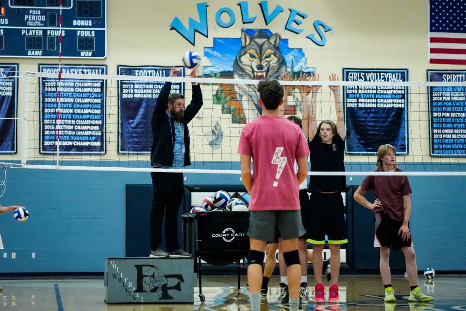 Head coach Michael Matteson stands on a box as he leads his boys' volleyball team in practice at Estrella Foothills High School on March 27, 2023, in Goodyear, Ariz.