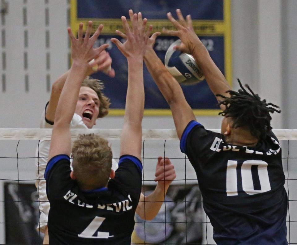 Spencerport's Collin Auburn (14), top left, spikes the ball into the defense of Brockport's Francis Nwokonko (10), right, and Andrew Wilson (4), during their Class B boys volleyball championship finals Thursday, Nov. 10, 2022 at Victor High School.