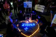 <p>Demonstrators construct a heart out of candles during a vigil protesting the death of a young Iranian Kurdish woman, Mahsa (Zhina) Amini, outside the Wilshire Federal Building in Los Angeles, California, U.S., September 22, 2022. REUTERS/Bing Guan</p> 