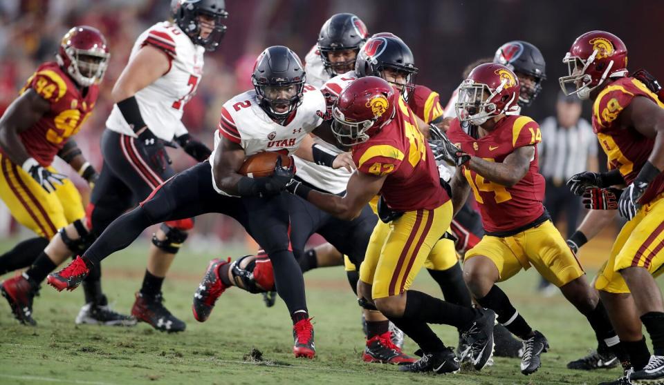 USC outside linebacker Uchenna Nwosu, right, tries to tackle Utah running back Zack Moss.