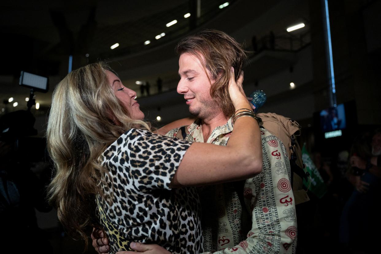 A family member greets Jonathan Hainsworth on his arrival at O.R. Tambo International Airport after he was evacuated from Sudan to escape the conflict (REUTERS)