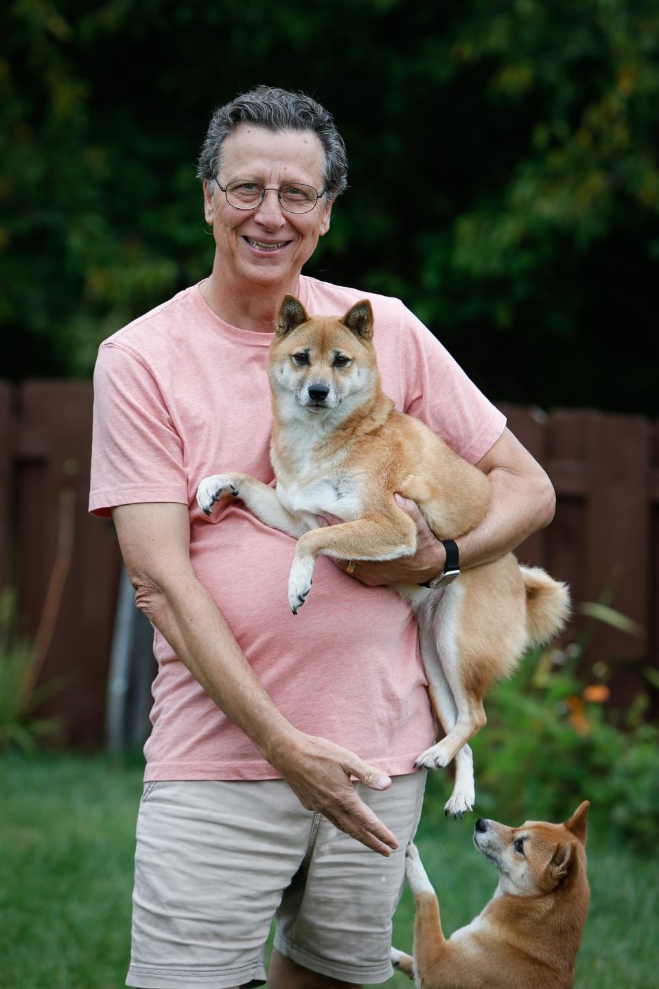 John Michno poses for a photo with his Shiba Inu Izzy and her sister Emmie, bottom corner, in his backyard in Battlefield on Friday, Sept. 22, 2023. In March, Michno became a host on Sniffspot, a private dog park rental service.