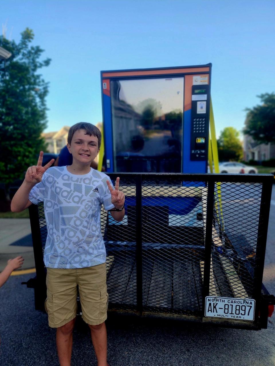Carter stands with a vending machine that he hopes will help raise funds to pay for his special needs education at   Fayetteville's only autism school.
