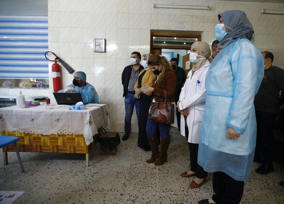 Iraqi health personnel wait to receive a coronavirus vaccine at a clinic in Baghdad, Iraq, Tuesday, March 2, 2021. (AP/Photo/Hadi Mizban)