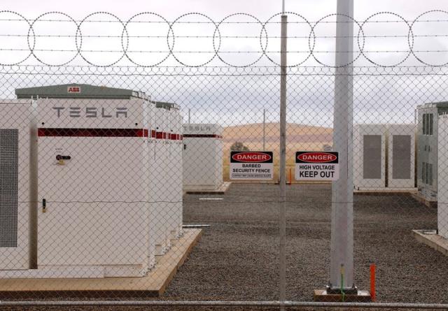 FILE PHOTO: Warning signs adorn the fence surrounding the compound housing the Hornsdale Power Reserve, featuring a lithium-ion battery made by Tesla, near the South Australian town of Jamestown