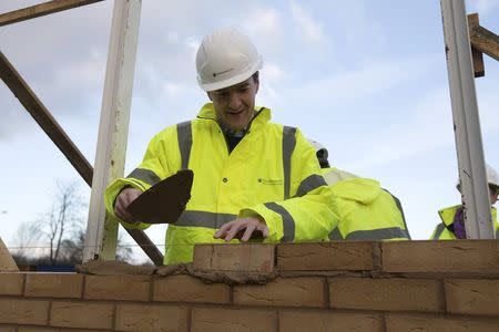 Britain's Chancellor of the Exchequer George Osborne lays a brick during a visit to a housing development in South Ockendon in Essex, Britain November 26, 2015. REUTERS/Carl Court/Pool