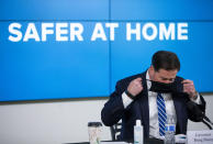 Arizona Gov. Doug Ducey puts on his face mask during a news conference about the coronavirus, Thursday, July 16, 2020, in Phoenix. (Cheryl Evan/The Arizona Republic via AP, Pool)