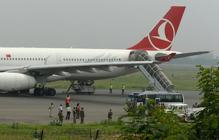 Officials gather around a Turkish Airlines aircraft as it sits on the tarmac at Indira Gandhi International Airport in New Delhi on July 7, 2015 following an emergency landing