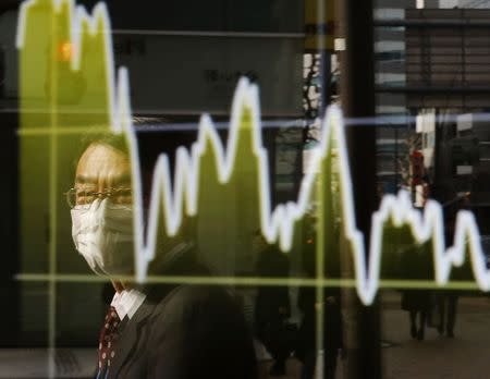 A man is reflected on an electronic board showing Japan's Nikkei average, outside a brokerage in Tokyo January 16, 2015. REUTERS/Toru Hanai