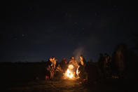 Huenchupan family members gather around a campfire as part of celebrations of We Tripantu, the Mapuche new year, in Lof Soyinka, Los Rios, southern Chile, on Wednesday, June 22, 2022. Coinciding with the winter solstice in the Southern Hemisphere, the late June festivities mark the "new rising of the sun" and signify "the change and renovation of life, in all senses," according to Amanda Huichalaf. (AP Photo/Rodrigo Abd)