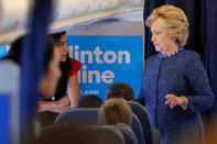 U.S. Democratic presidential nominee Hillary Clinton talks to staff members, including aide Huma Abedin (L), onboard her campaign plane in White Plains, New York, U.S. October 28, 2016. REUTERS/Brian Snyder