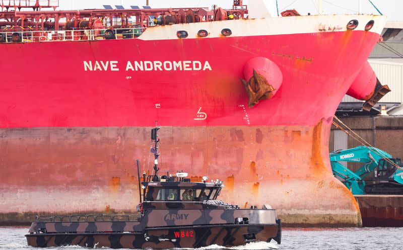 A military boat passes in front of the Liberia-flagged oil tanker Nave Andromeda at Southampton Docks, following a security incident aboard the ship the night before off the coast of Isle of Wight, in Southampton