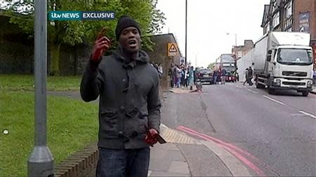 Michael Adebolajo shows a bloodied hand and knives following the murder of soldier Drummer Lee Rigby in Woolwich on May 22, 2013, in this still image obtained from video December 19, 2013. REUTERS/ITV News via Reuters TV