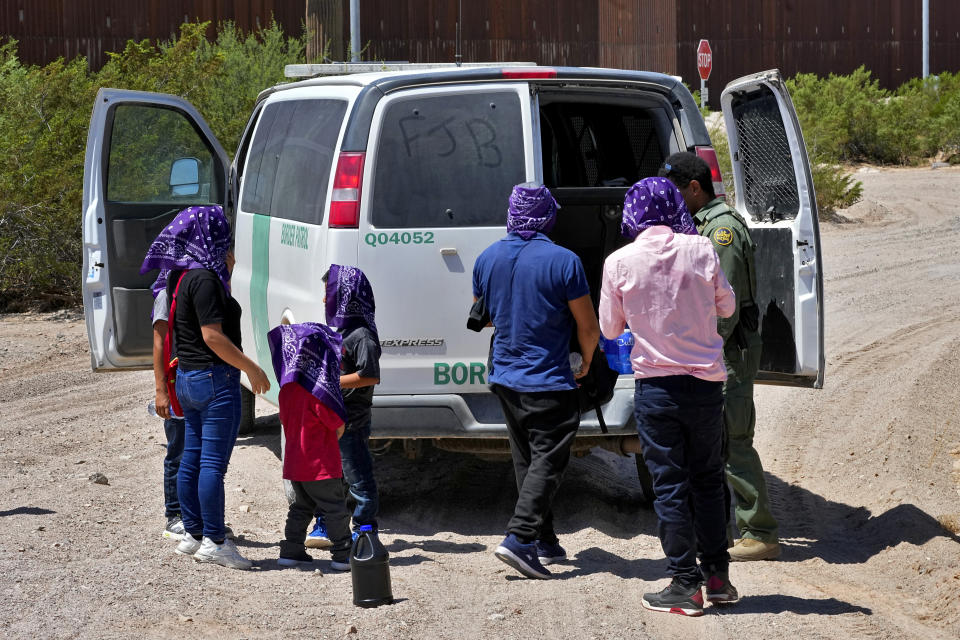 A family of five claiming to be from Guatemala and a man from Peru, in pink shirt, are picked up by a Customs and Border Patrol agent after the group crossed the border fence in the Tucson Sector of the U.S.-Mexico border, Tuesday, Aug. 29, 2023, in Organ Pipe Cactus National Monument near Lukeville, Ariz. CBP rescues by air and land along the U.S. border with Mexico are soaring this year, with 28,537 counted during the 10-month period ending July 31. That compares with 22,072 tallied during the 12-month period ending Sept. 30, 2022, the agency said. There were 2,776 migrant rescues in July. (AP Photo/Matt York)