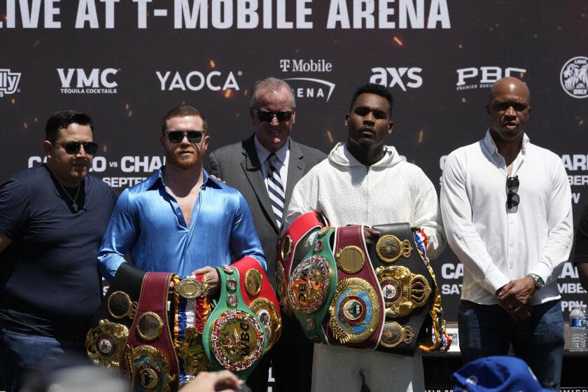 Undisputed super middleweight world champion Canelo Álvarez, second from left of Mexico, his trainer, Eddy Reynoso, left, undisputed junior middleweight world champion Jermell Charlo, second from right, is trainer Derrick James, right, pose for pictures with promoter Tom Brown, center, during a boxing news conference with undisputed junior middleweight world champion Jermell Charlo, Wednesday, Aug. 16, 2023, in Beverly Hills, Calif. (AP Photo/Damian Dovarganes)