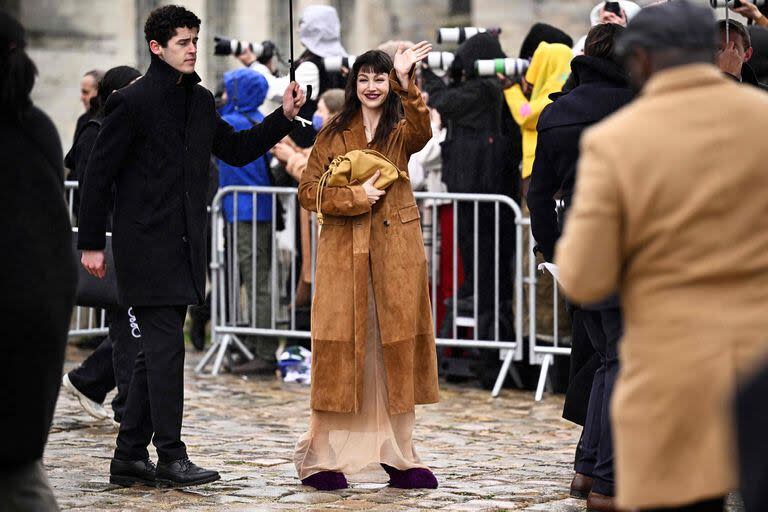 Úrsula Corberó volvió a dar la nota con su look. Esta vez, la actriz pasó por la Semana de la Moda de París y, luego del desfile de Loewe, compartió su original outfit con el público. Sin el Chino Darín, su novio, como acompañante, la protagonista de El cuerpo en llamas llevó un vestido largo de tul en color nude que acompañó con un sacón camel y unos voluminosos zapatos de pelo color vino