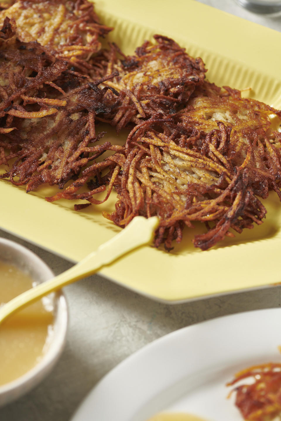 Plates of potato pancakes, or latkes, are displayed in New York in August 2020. Latkes are the food most traditionally associated with Hanukkah. There are all kinds of modern variations using other vegetables and other toppings. (Cheyenne M. Cohen via AP)