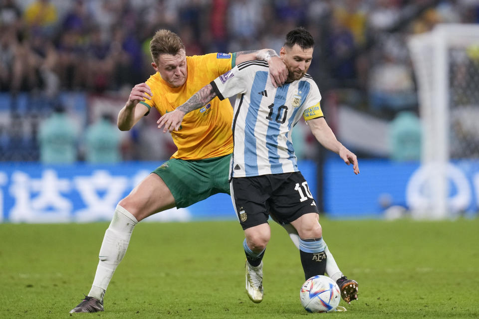 Australia's Harry Souttar, left, and Argentina's Lionel Messi during the World Cup round of 16 soccer match between Argentina and Australia at the Ahmad Bin Ali Stadium in Doha, Qatar, Saturday, Dec. 3, 2022. (AP Photo/Thanassis Stavrakis)