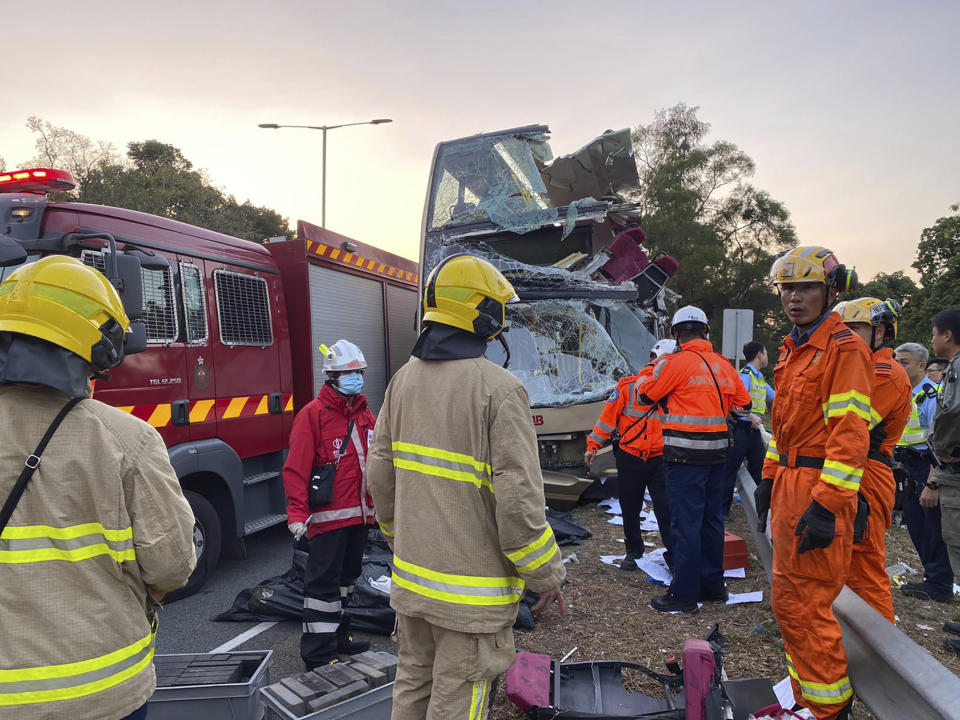 In this photo provided by Hong Kong Police Force, firemen investigate a double-decker bus after its crash on a highway from the town of Fanling, in Hong Kong Wednesday, Dec. 18, 2019. Hong Kong emergency services say a violent crash of a double-decker bus has killed multiple people and injured more than 20 others. (Hong Kong Police Force via AP)