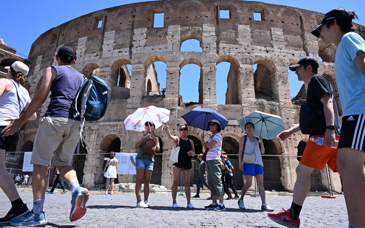 Tourists under umbrellas at the Colosseum, Rome