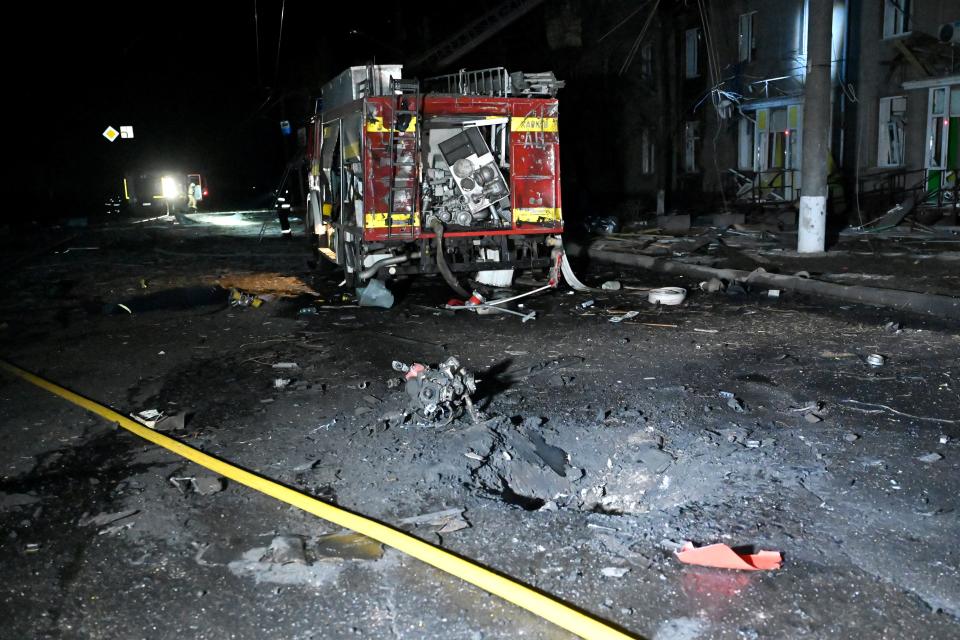 A crater can be seen next to a damaged fire truck in Kharkiv (AFP via Getty Images)