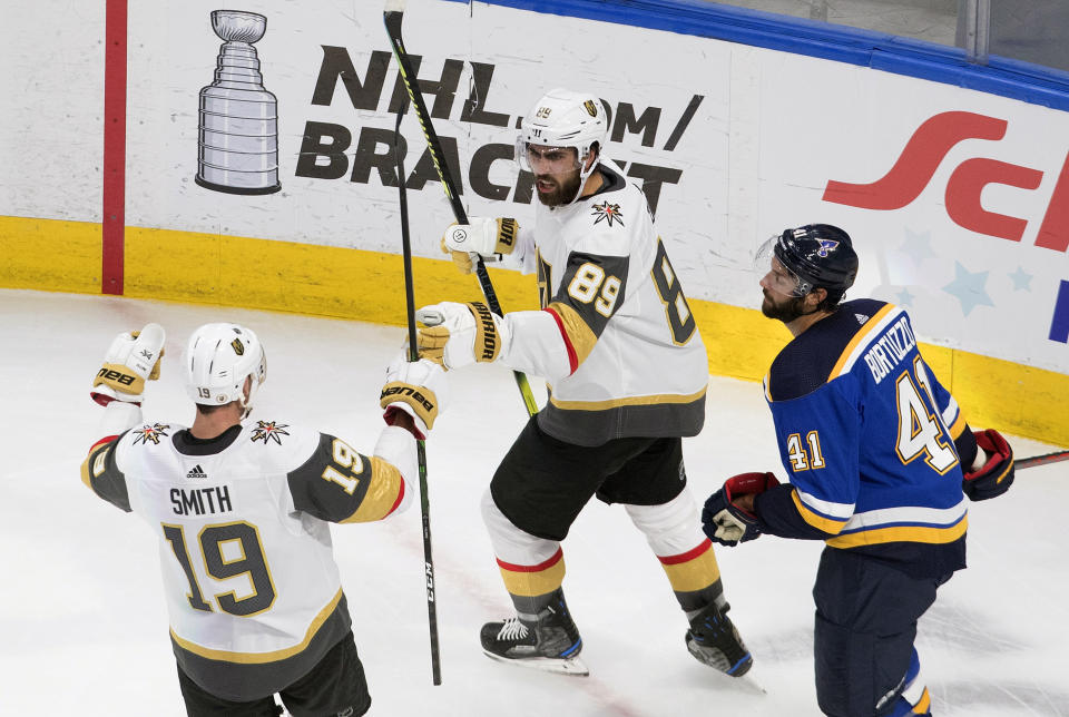 St. Louis Blues' Robert Bortuzzo (41) looks on as Vegas Golden Knights' Reilly Smith (19) and teammate Alex Tuch (89) celebrate a goal during the second period of an NHL hockey playoff game Thursday, Aug. 6, 2020, in Edmonton, Alberta. (Jason Franson/Canadian Press via AP)