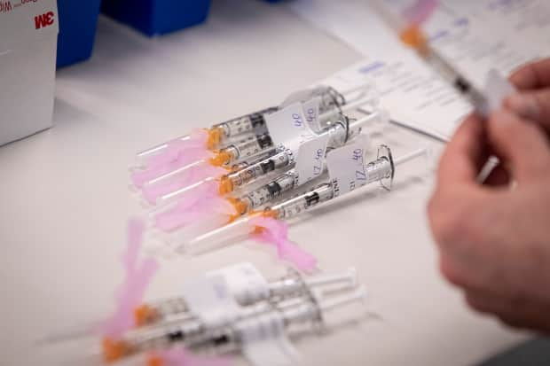 A nurse prepares doses of the Pfizer-BioNTech COVID-19 vaccine at a clinic at St. Michael’s Hospital in Toronto on Dec. 22. Experts say we may not be able to vaccinate enough of the population fast enough in Canada to adequately slow the spread of variants in time before they take over. 