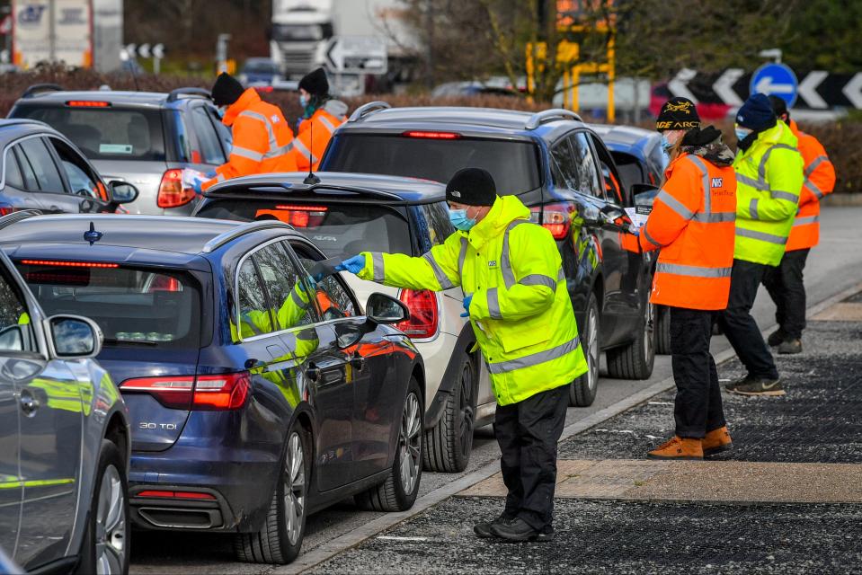 Testing staff hand out kits to motorists attending a surge testing centre at the Science Park, Emersons Green, in Bristol, Gloucestershire (PA)