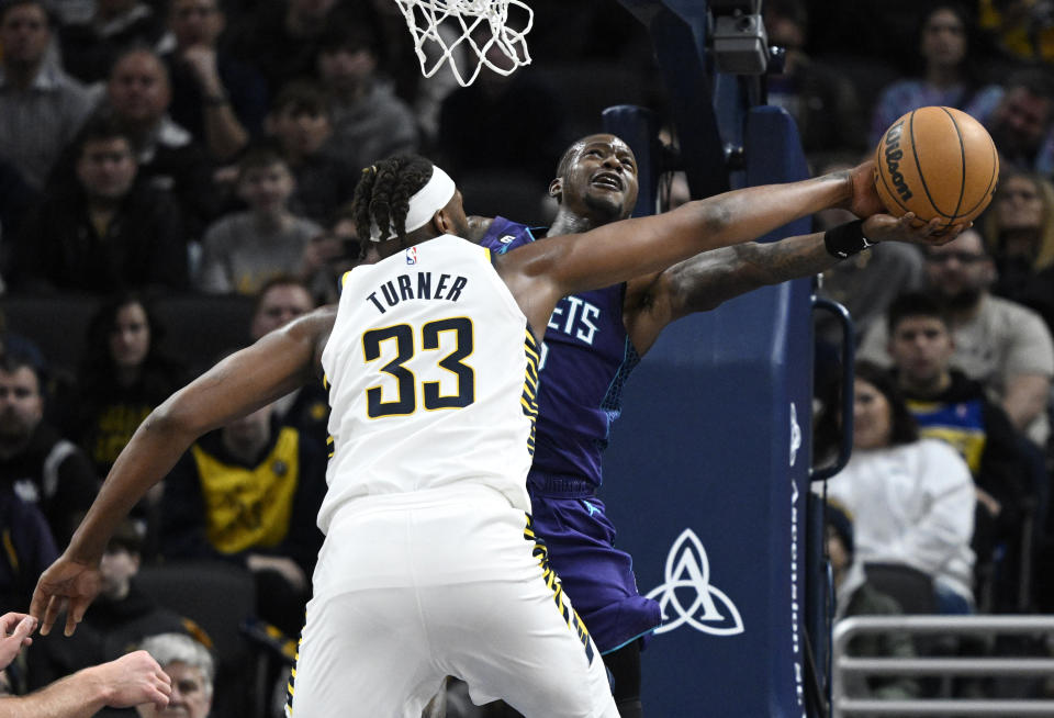 Indiana Pacers center Myles Turner (33) blocks a shot by Charlotte Hornets guard Terry Rozier, right, during the second half of an NBA basketball game, Sunday, Jan. 8, 2023, in Indianapolis. (AP Photo/Marc Lebryk)