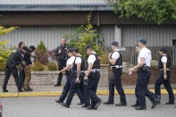 Cadets at the Washington state Criminal Justice Training Commission, walk past a training exercise in progress, Wednesday, July 14, 2021, in Burien, Wash. Washington state is embarking on a massive experiment in police reform and accountability following the racial justice protests that erupted after George Floyd's murder last year, with nearly a dozen new laws that took effect Sunday, July 25, but law enforcement officials remain uncertain about what they require in how officers might respond — or not respond — to certain situations, including active crime scenes and mental health crises. (AP Photo/Ted S. Warren)