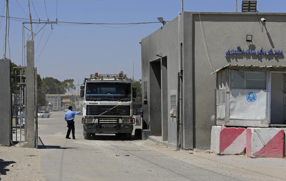 A Hamas security officer checks a truck entering Gaza at the gate of the Kerem Shalom cargo crossing with Israel, in Rafah, southern Gaza Strip, Monday, June 21, 2021. Israel on Monday eased some restrictions on the Gaza Strip that have threatened a fragile cease-fire which halted an 11-day war last month with the territory's Hamas rulers, Palestinian officials said. (AP Photo/Adel Hana)