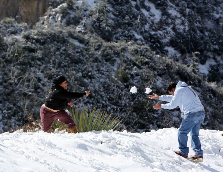 Veronica Ojeda, 40 of Van Nuys, left, and Efren Dominguez, 43 of Arleta, right, throw snowballs at each other on