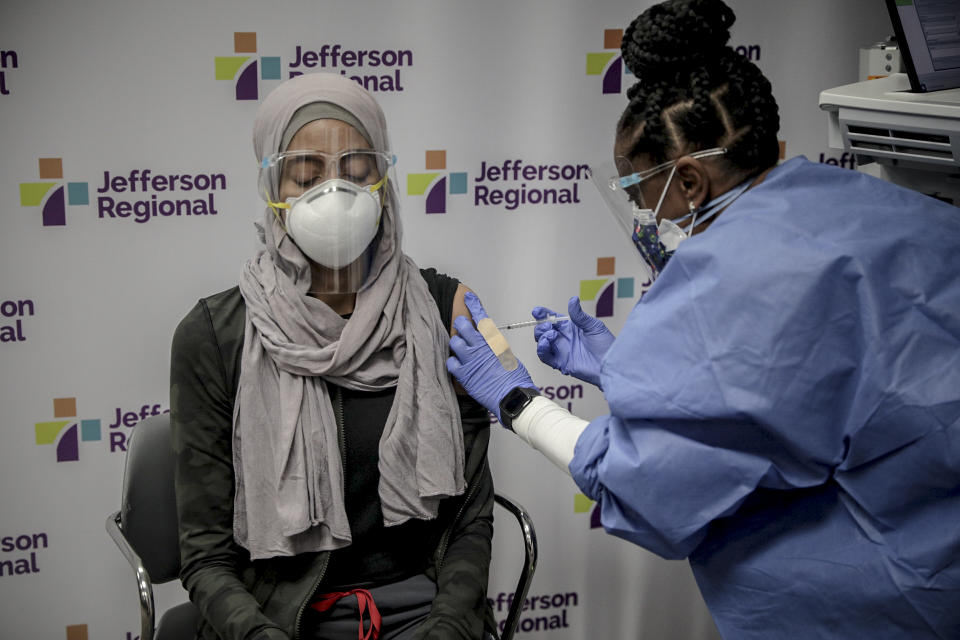 Nazin Jamal, a la izquierda, que trabaja en el piso COVID-19 del Centro Médico Regional Jefferson, recibe la vacuna en Pine Bluff, Arkansas, el 15 de diciembre de 2020. (Andrea Morales/The New York Times)