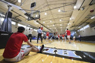 Worcester Polytechnic Institute's Ethan Harrell, left, warms up in a mostly empty Goldfarb Gymnasium at Johns Hopkins University before playing against Yeshiva University in a first-round game at the men's Division III NCAA college basketball tournament, Friday, March 6, 2020, in Baltimore. The university held the tournament without spectators after cases of COVID-19 were confirmed in Maryland. (AP Photo/Terrance Williams)