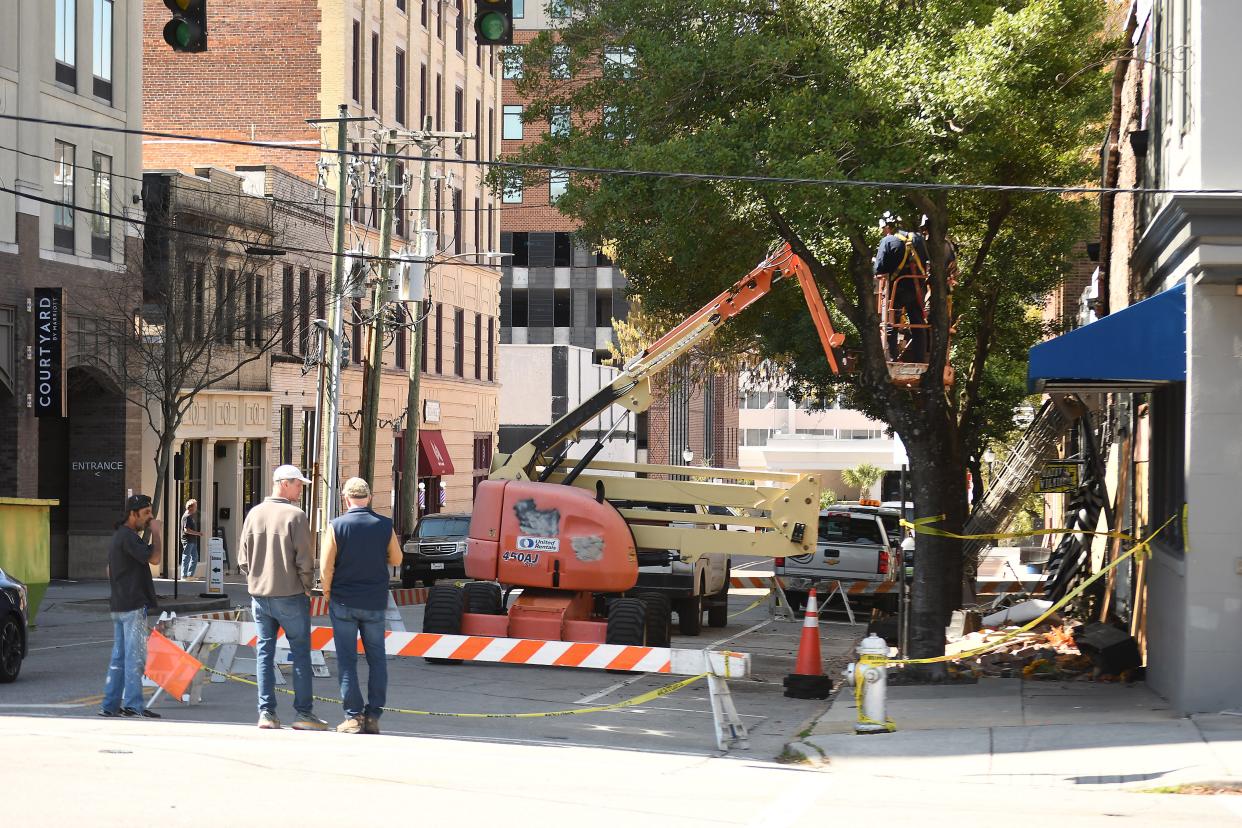 Crews look over damage caused Thursday night after the collapse of an exterior façade that damaged some of the buildings and cars off of Grace Street in downtown Wilmington. One person had minor injuries according to a Facebook post from the Wilmington Fire Department.