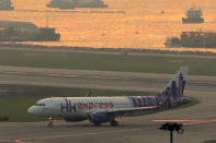 In this March 26, 2019 photo, a Hong Kong Express Airways passenger aircraft lands at the Hong Kong International Airport. Cathay Pacific Airways is acquiring Hong Kong-based budget airline HK Express. Cathay said Wednesday, March 27, 2019, it will pay 4.93 billion Hong Kong dollars ($628 million) for HK Express. It said the acquisition will retain its identity as a separate brand and be operated as a low-cost carrier. (AP Photo/Kin Cheung)