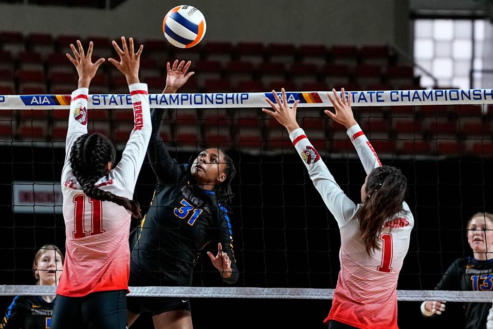 Phoenix Country Day School’s Mia Walker, center, prepares to hit the ball as St. John's High School’s Gaby Gala, left, and Alexis Black, right, attempt to block during the AIA 2A Girls Volleyball Championship game at the Arizona Veterans Memorial Coliseum in Phoenix on November 12, 2022.