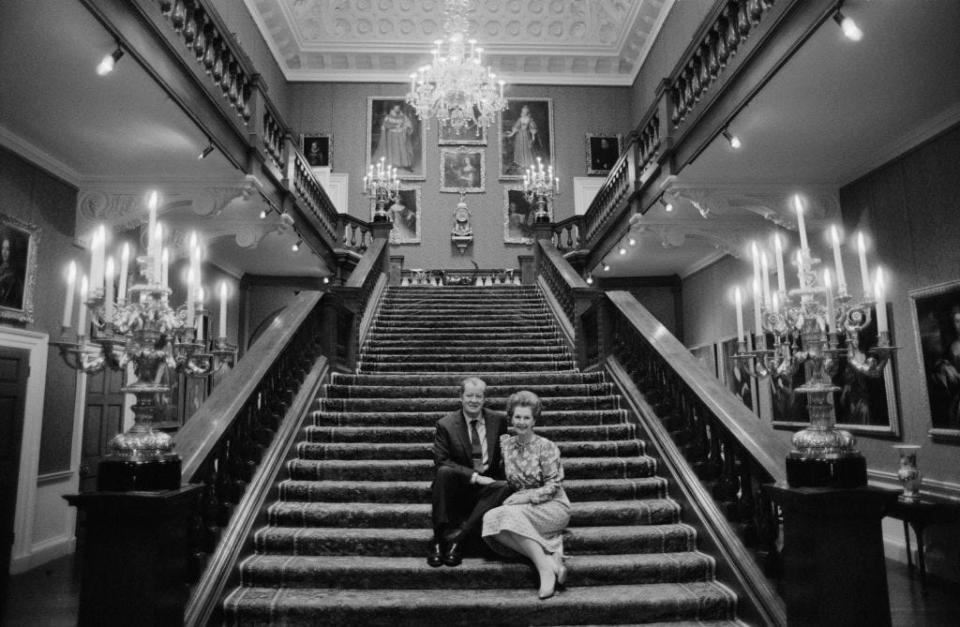 John Spencer and Raine, Countess Spencer at Althorp, sit on a staircase in Althorp House in 1986.