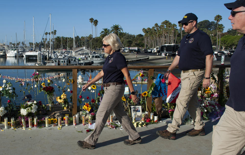 National Transportation Safety Board member Jennifer Homendy and her team walk past a memorial for the victims of a dive boat fire at Santa Barbara Harbor on Wednesday, Sept. 4, 2019 in Santa Barbara, Calif. A fire raged through a boat carrying recreational scuba divers anchored near an island off the Southern California Coast on Monday, Sept. 2, leaving multiple people dead.(AP Photo/Christian Monterrosa )