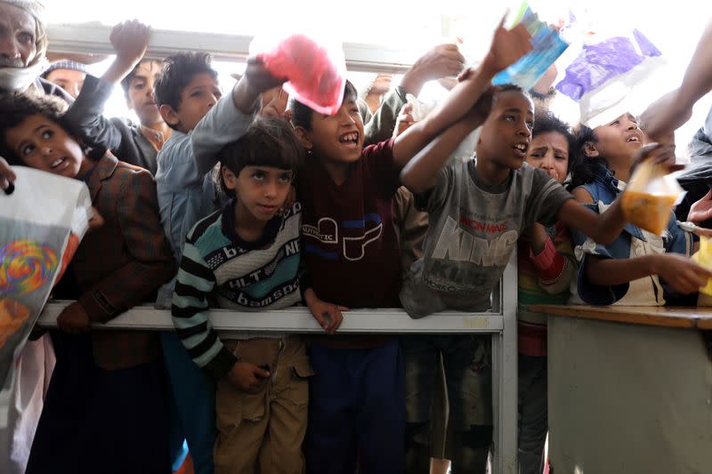 People crowd to get food rations from a charity kitchen in Sanaa