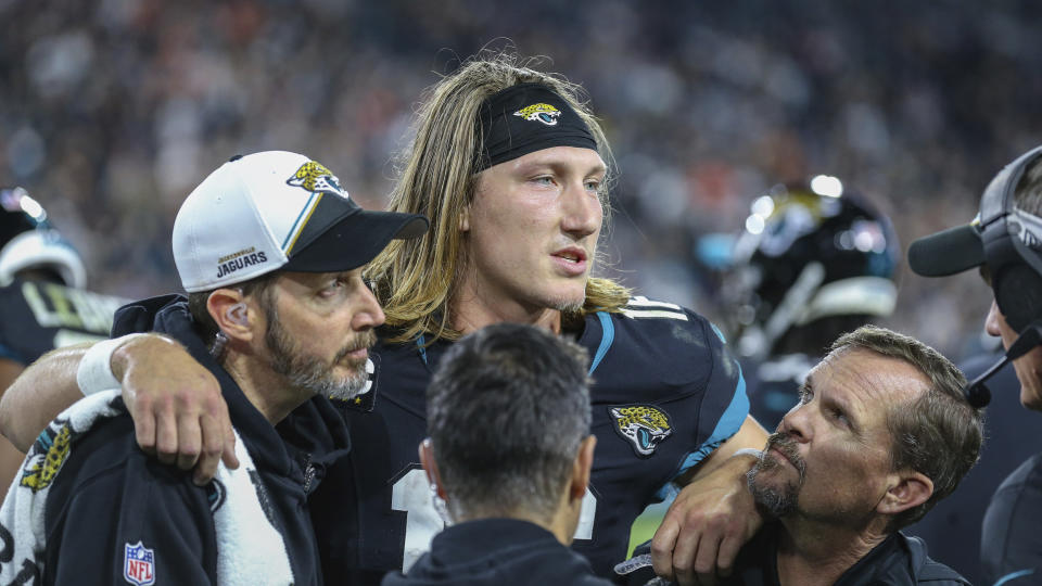 Jacksonville Jaguars quarterback Trevor Lawrence (16) is helped from the bench area after suffering a high ankle sprain. (AP Photo/Gary McCullough)