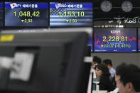 Currency traders watch computer monitors near the screens showing the Korea Composite Stock Price Index (KOSPI), right, and the foreign exchange rates at the foreign exchange dealing room in Seoul, South Korea, Wednesday, Jan. 15, 2020. Asian shares have retreated as conflicting reports raised concerns over the likely outcome of a trade deal to be signed by the U.S. and China. (AP Photo/Lee Jin-man)