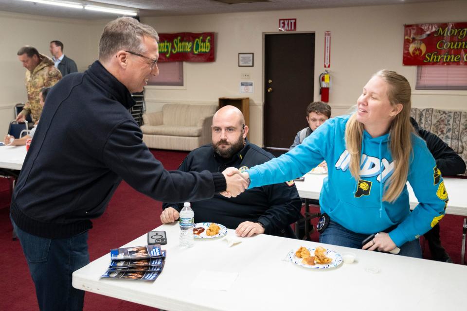 Eric Doden, an Indiana Republican gubernatorial candidate, shakes hands with Ashley Johnson, a police officer with the Brooklyn Police Department, on Wednesday, April 3, 2024, during a Morgan County Fraternal Order of Police Lodge 119 meeting at the Martin County Shrine Club in Martinsville, Indiana.