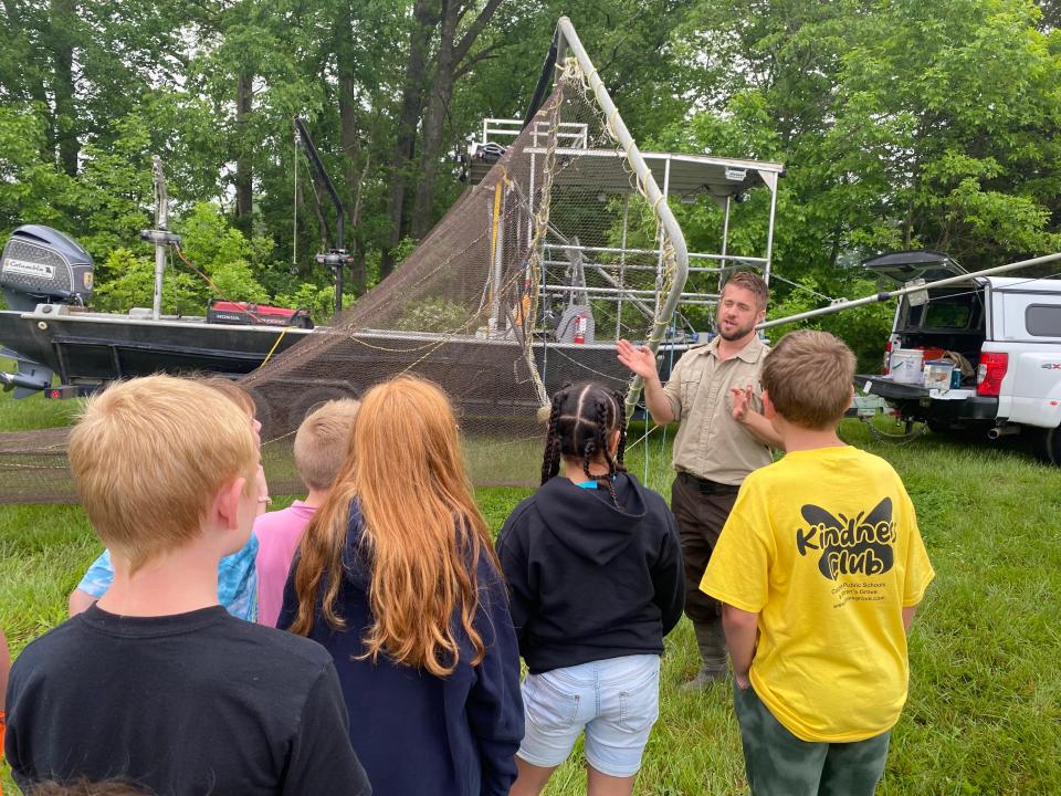 Kevin Drews, fisheries biologist with the U.S. Fish and Wildlife Service, on Wednesday explains the electro-fishing boat to students at Two Mile Prairie Elementary School.